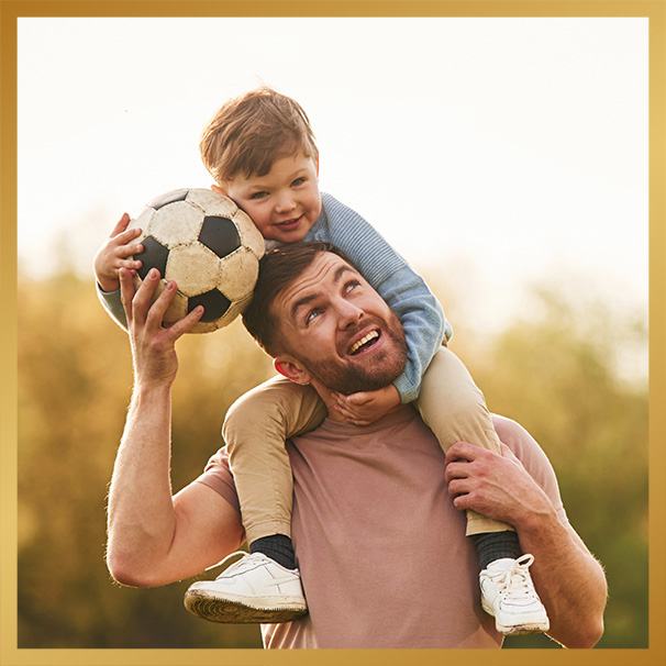 Happy father with son are having fun on the field at summertime