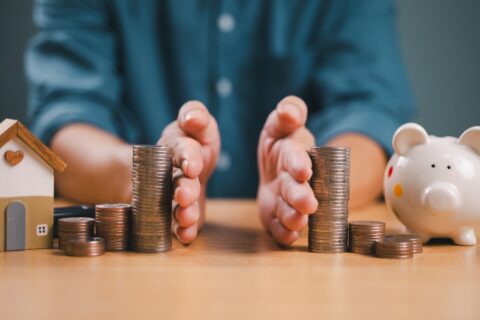 Man's hands around coin stacks signifying dividing of money and property for divorce