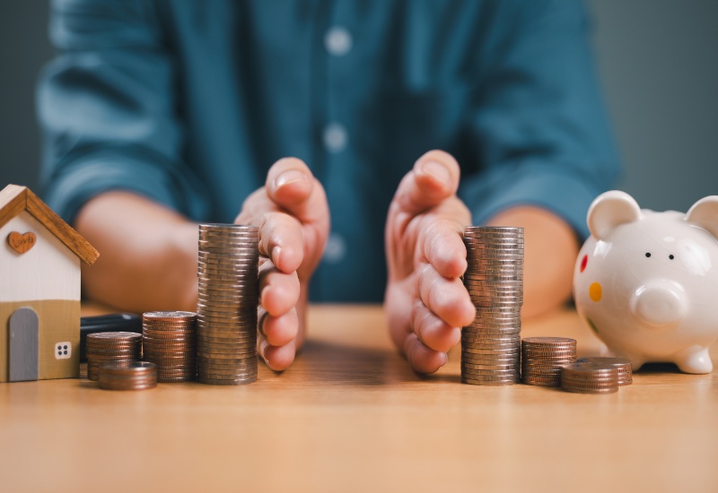 Man's hands around coin stacks signifying dividing of money and property for divorce