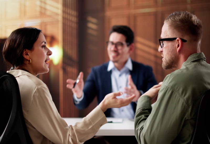 A Couple Discussing Legal Matters with a Mediator at a Desk in Tucson and Pima County, AZ