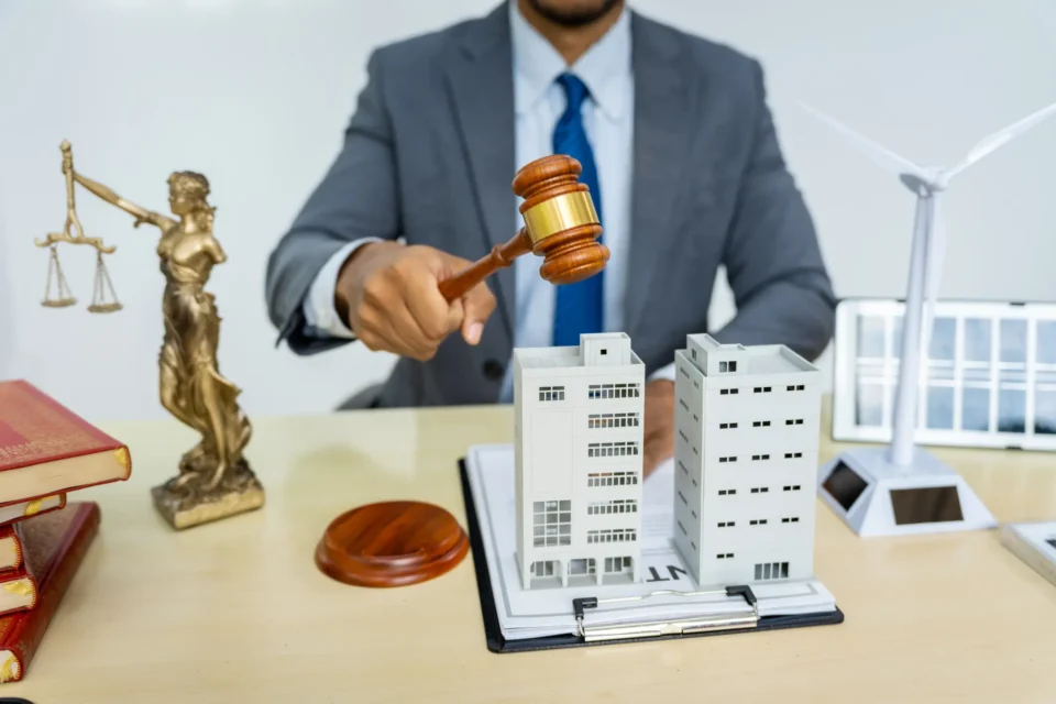 Attorney managing complex property division case with real estate models and gavel on desk